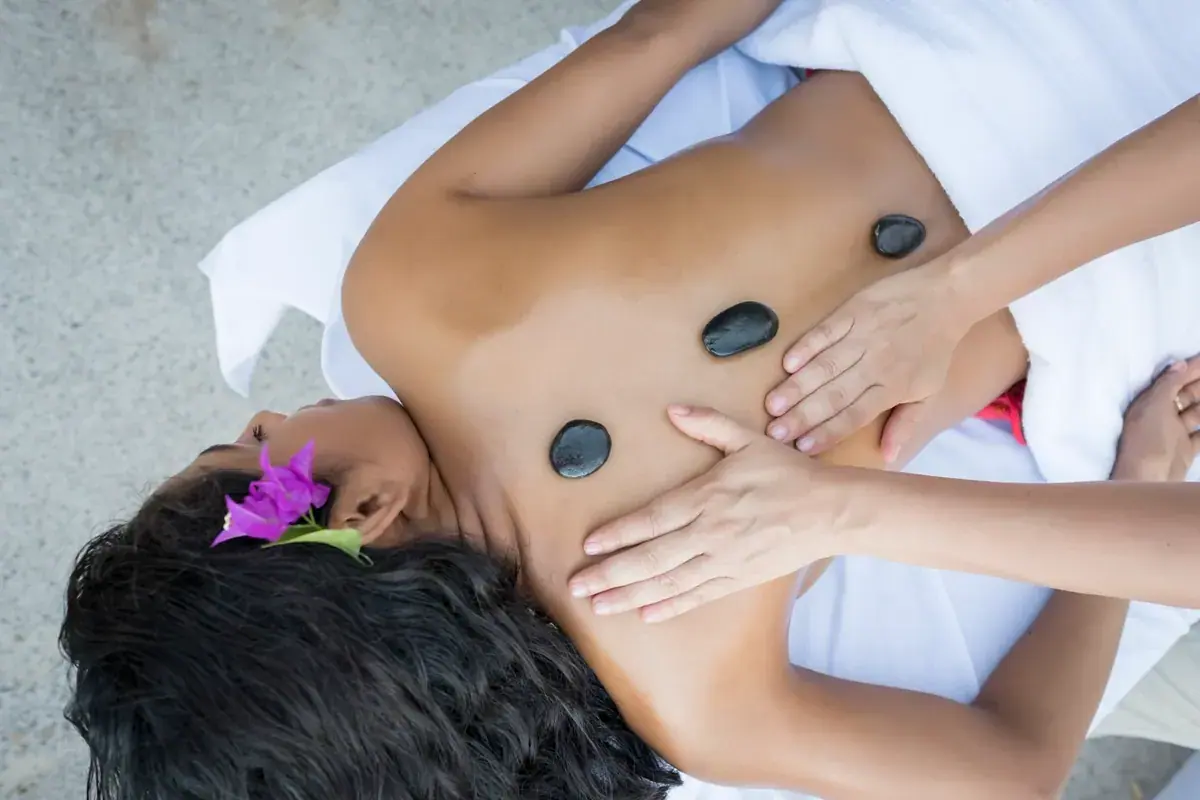 Hot stones placed on a person's back during a massage at Bain des Sens Spa in Paris