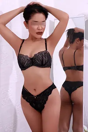 Woman in black lace lingerie posing with her hands in her hair beside a mirror, BambooBKK, Bangkok