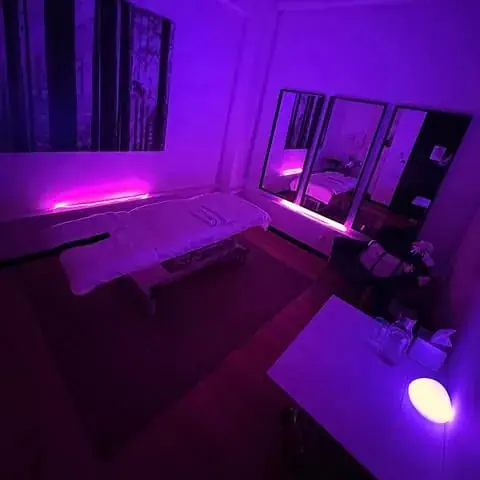 Massage room at Czech Massage Sydney with a treatment table, wall mirrors and purple ambient lighting