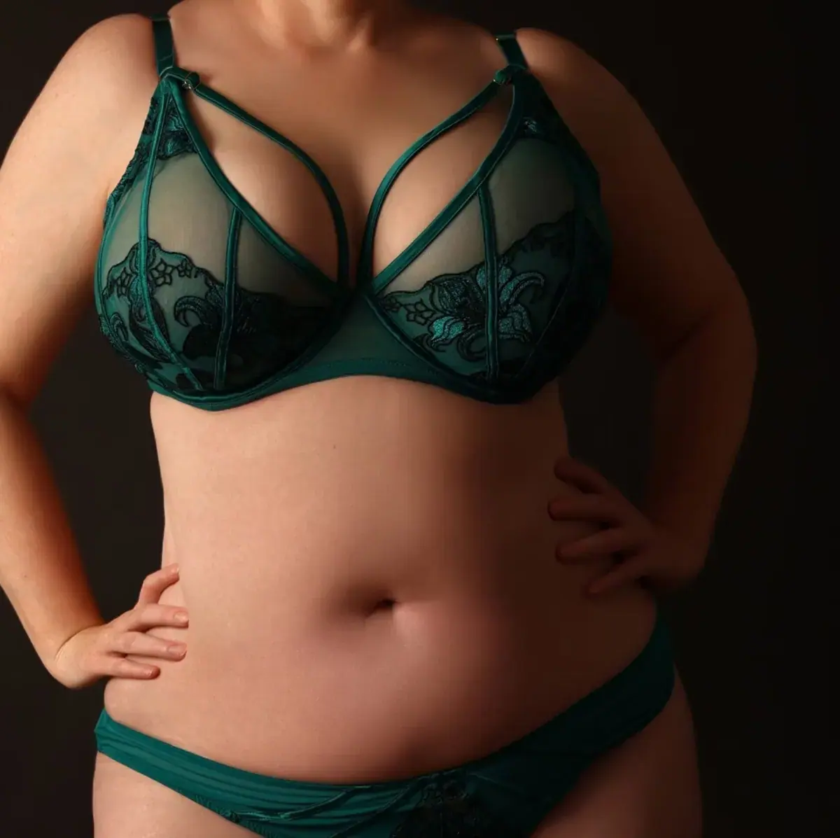 Cropped studio photo of a woman in a green lace lingerie set, posed for Edra Sage in London