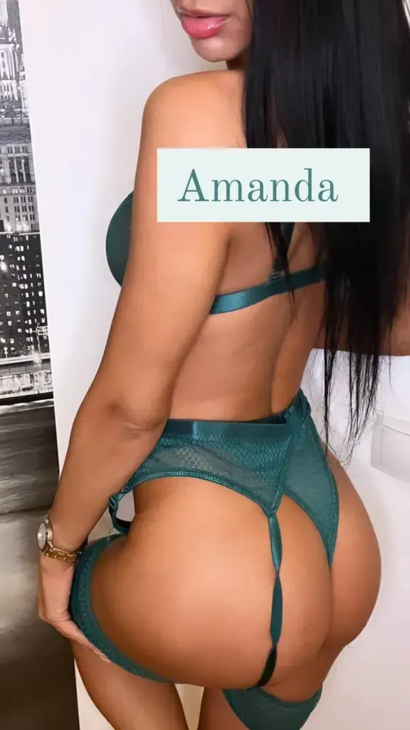 A woman with long dark hair posing in green lingerie with a garter set, seen from behind, at Eros Spa in Bucharest