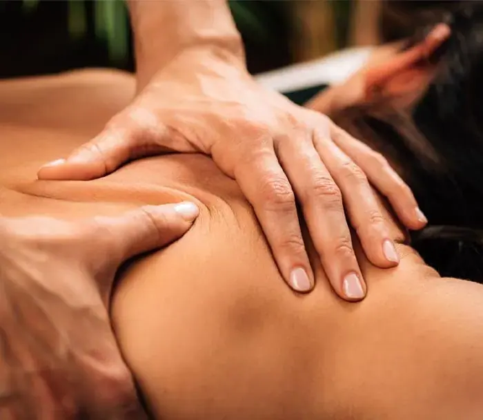 Close-up of a therapist's hands massaging a client's shoulder and upper back at Euphoria Massage in Budapest