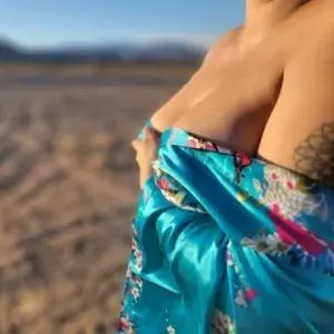 Person wrapped in a turquoise floral silk robe standing on a desert flat, promoting Las Vegas Tantra in Las Vegas