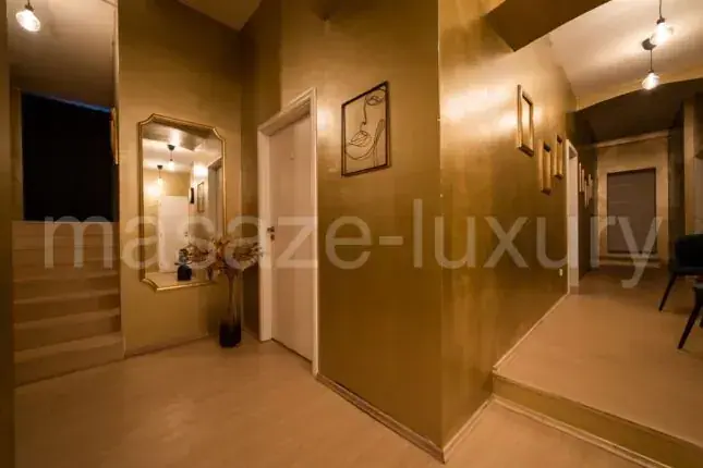 Golden hallway with framed art and large mirror at Luxury Grand in Prague