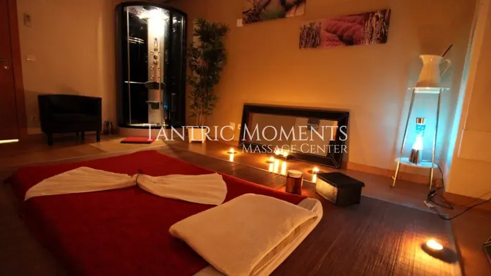 Massage room with floor mattress, candles, and shower at NURU Lovers in Lisbon