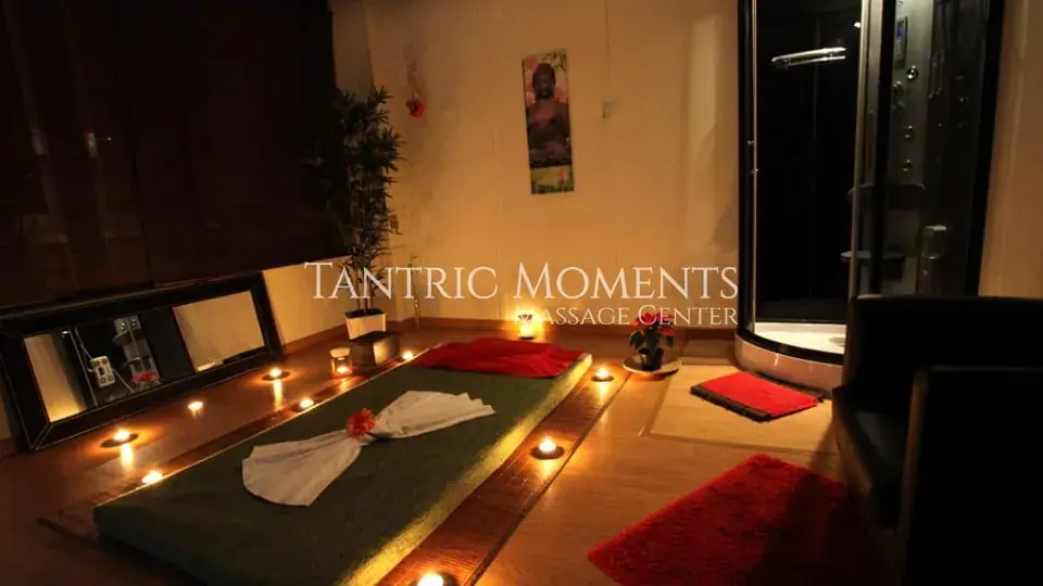 Candlelit massage room with floor mattress and shower at NURU Lovers in Lisbon