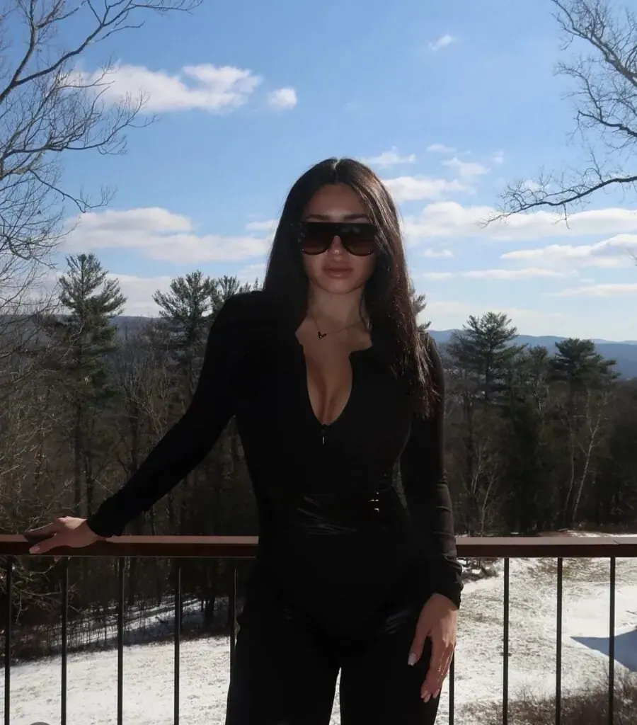 Masseuse from Nuru Secret in New York posing on a balcony against a forest landscape