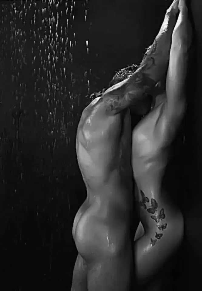 Black-and-white artistic photo of two nude figures embracing under falling water, used for Nuru Sensation in NYC, New York