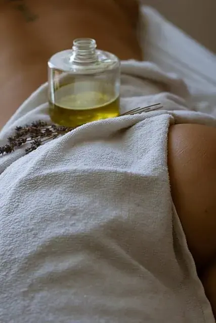 Massage oil bottle and a white towel on a client at Point of contact salon in Kyiv