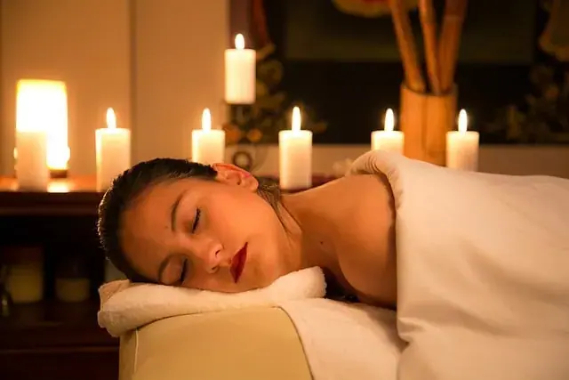 Woman resting with eyes closed on a massage table by candlelight, at Point of contact in Kyiv