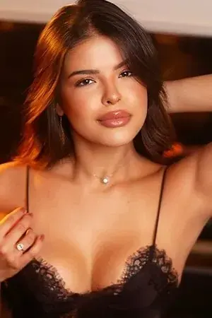 Portrait of a woman with shoulder-length brown hair in a black lace camisole, posing for RJ Massagem in Rio de Janeiro