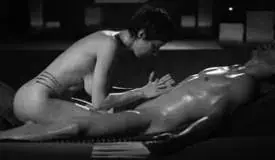 Black-and-white photo of a masseuse leaning over an oiled client during a massage at Salon Imperial in Prague