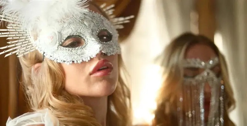 Two women in ornate lace and beaded masquerade masks, one with white feathers, at Soho Spa in Moscow