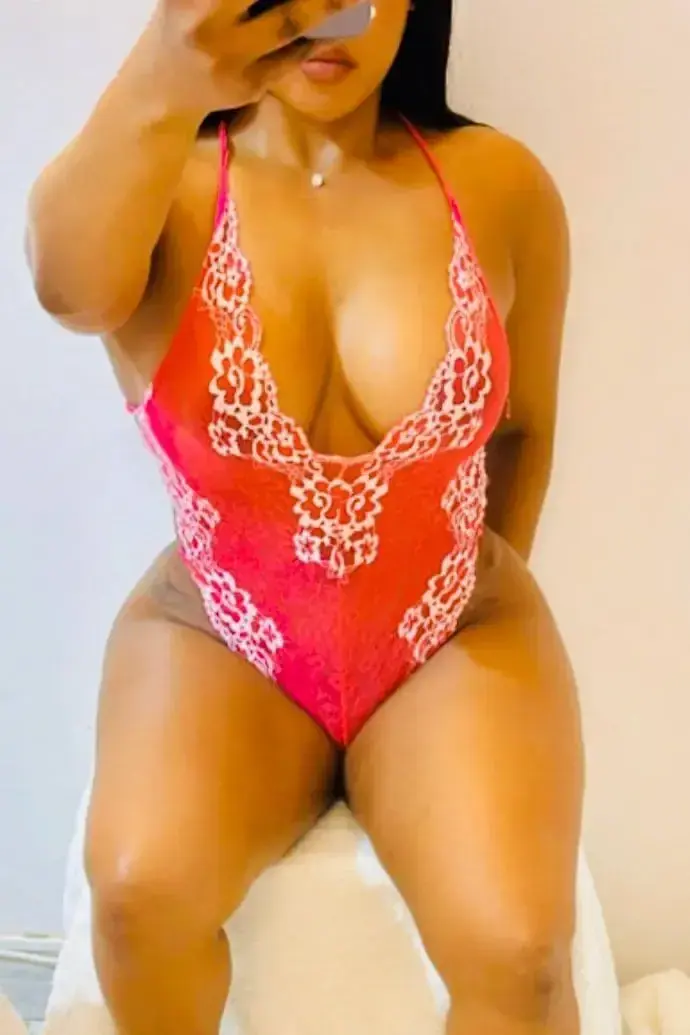 A woman in a red and white lace bodysuit takes a mirror selfie, shown for Sol Massagens in Lisbon