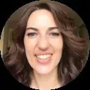 Smiling woman with wavy brown hair in a close-up portrait, linked to Tantra masajes barcelona in Barcelona