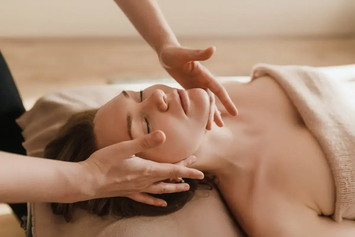 A woman receiving a relaxing face massage at Tantra Massages Warsaw
