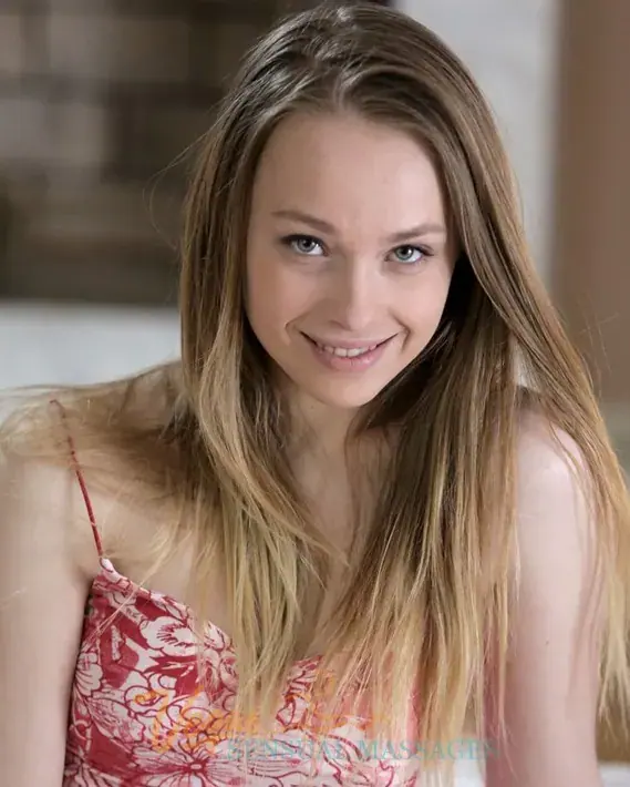 Smiling young woman with long light brown hair in a red floral camisole, photographed for Vegas Sensual Massages in Las Vegas